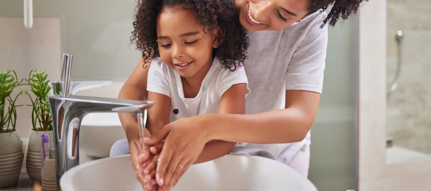 Woman and daughter washing hands